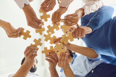 Decorative Image showing adults each holding a puzzle piece