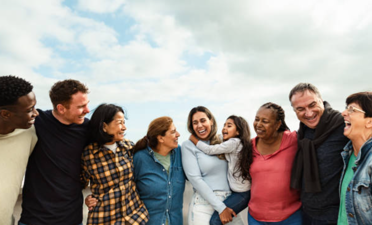 Image of several adults and one child standing shoulder to shoulder smiling