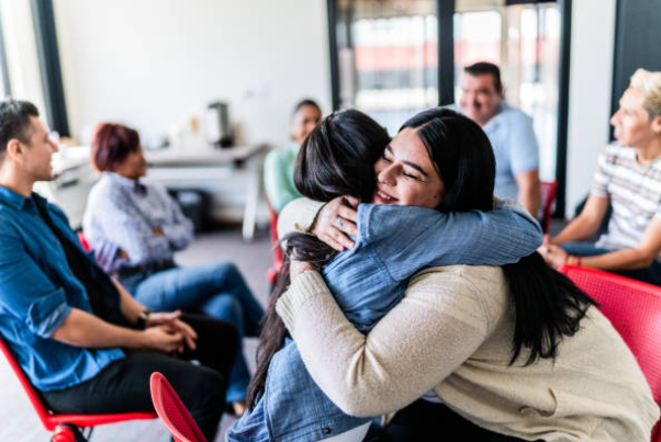 Image of parents engaged in conversation and hugging each each other in support