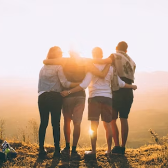 Image of a family hugging one another facing the sunset