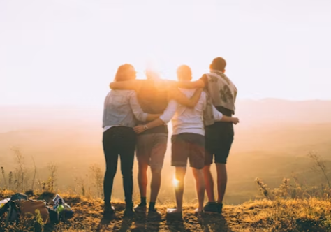 Image of a family hugging one another facing the sunset