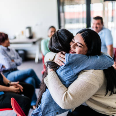 Image of parents engaged in conversation and hugging each each other in support